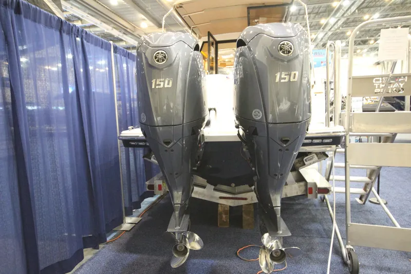 Slide: The Image of 2026 Ranger Tugs R-27 with dual 150 horsepower outboard motors at a boat show. - 1