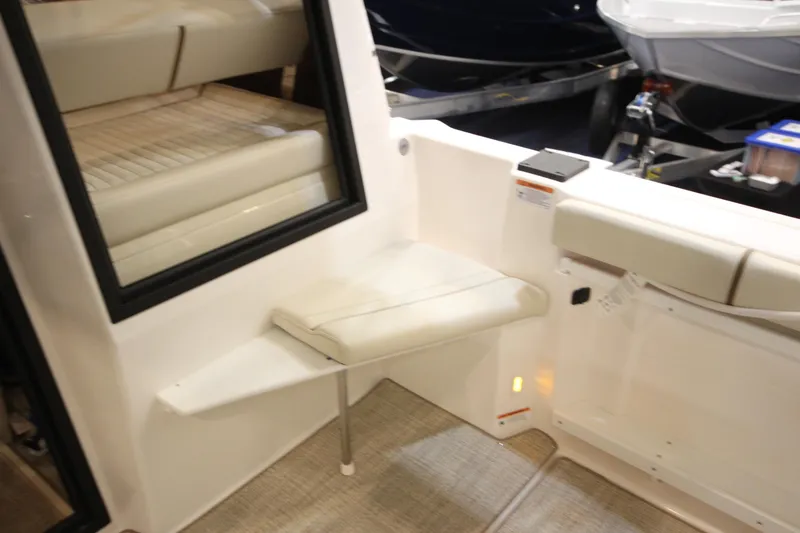 Slide: The Image of 2026 Ranger Tugs R-27 interior seating area with cushioned bench and window. - 17