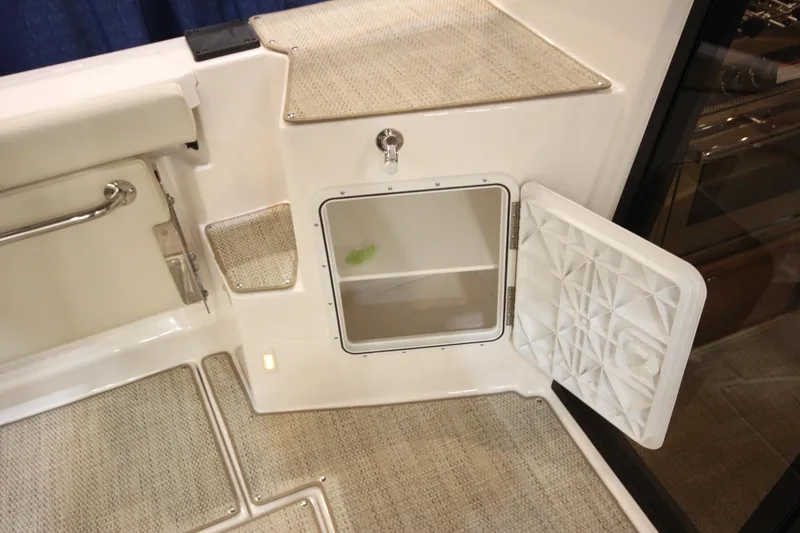 Slide: The Image of 2026 Ranger Tugs R-27 boat interior with open storage compartment and carpeted flooring. - 9