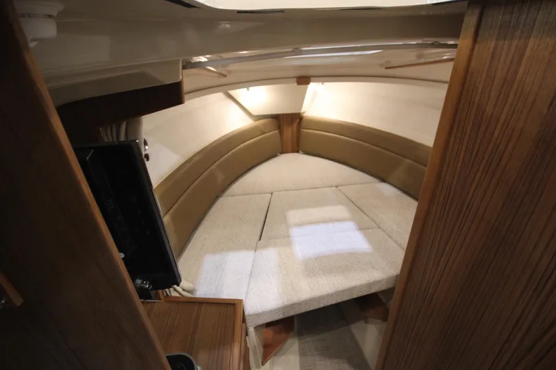 Slide: The Image of 2026 Ranger Tugs R-27 cabin interior with cozy seating and wood accents. - 16