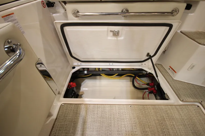 Slide: The Image of 2026 Ranger Tugs R-27 boat storage compartment with visible wiring and secure latch. - 6