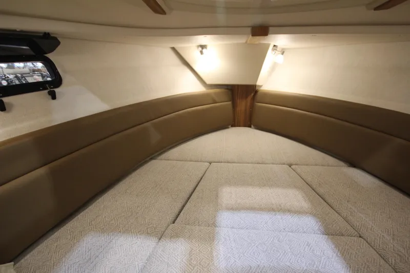 Slide: The Image of 2026 Ranger Tugs R-27 interior cabin with cushioned seating and soft lighting. - 24