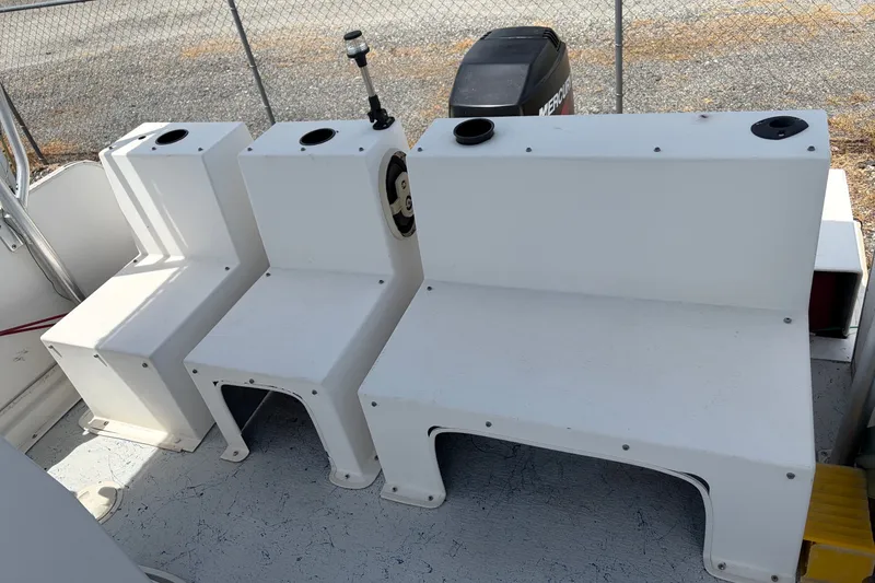 Slide: The Image of Interior of a 1998 Beachcat 19 boat showing white seating and a steering wheel. - 9