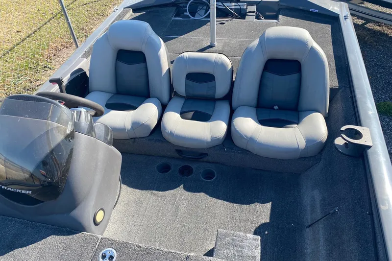Slide: The Image of 2018 Bass Tracker Pro 19 boat interior with three gray seats and steering console. - 4