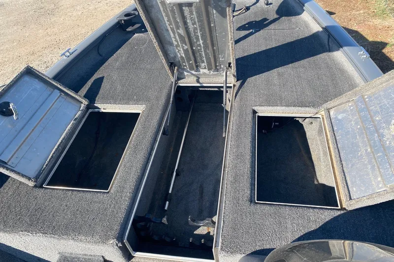 Slide: The Image of 2018 Bass Tracker Pro 19 boat with open storage compartments on deck. - 8