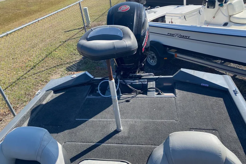 Slide: The Image of 2018 Bass Tracker Pro 19 boat with motor, parked near a fence. - 3