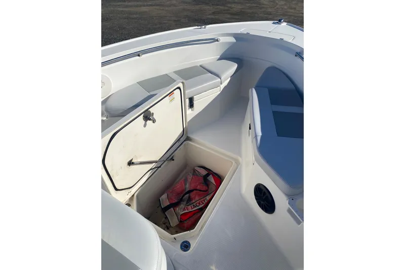 Slide: The Image of 2018 Mako 204 Center Console boat interior with open storage compartment and life jacket. - 5