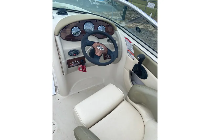 Slide: The Image of 2005 Sea Ray 200 Sundeck helm with steering wheel and control panel. - 2