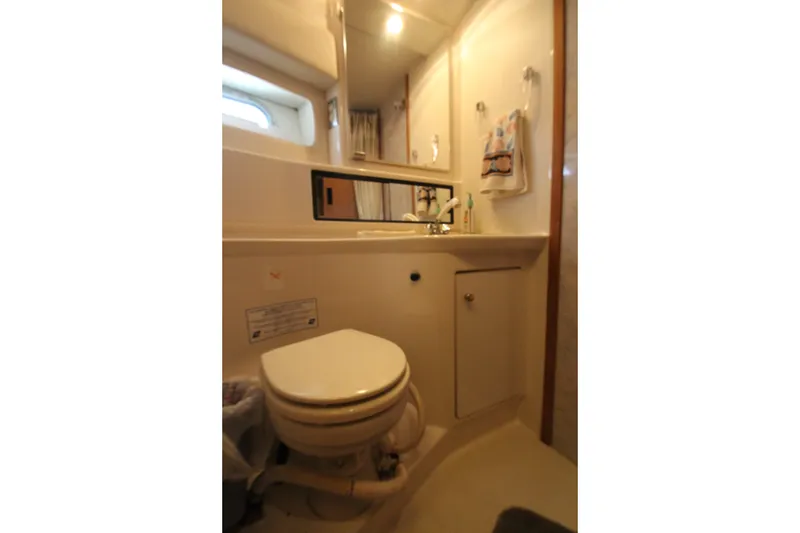 Slide: The Image of Bathroom interior of 1996 Bayliner 3988 Command Bridge Motoryacht, featuring toilet and sink. - 38