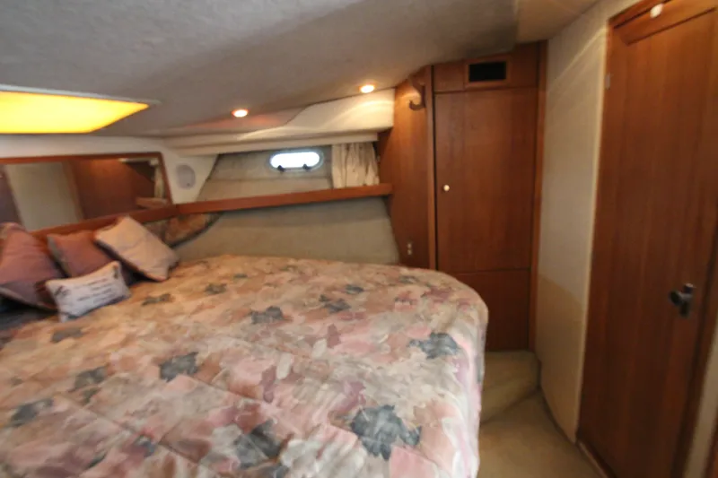 Slide: The Image of Cozy bedroom in 1996 Bayliner 3988 Command Bridge Motoryacht with wood accents and soft lighting. - 47