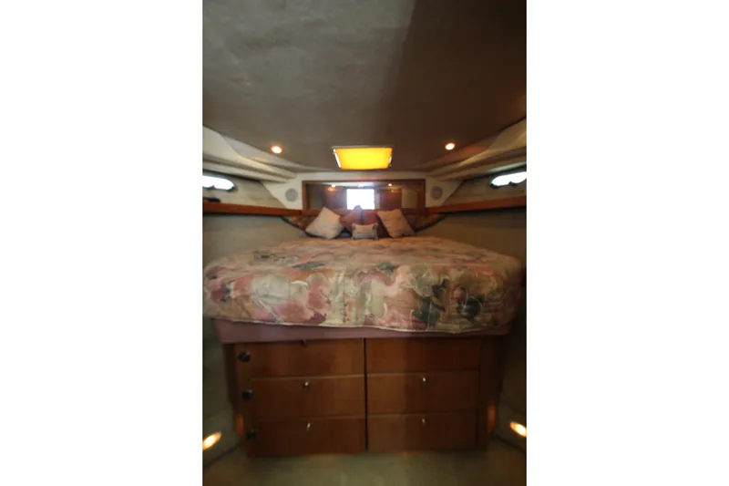 Slide: The Image of 1996 Bayliner 3988 Command Bridge Motoryacht cabin with cozy bed and wooden storage. - 40
