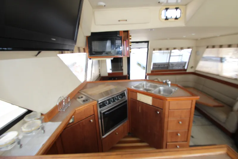 Slide: The Image of Interior of 1996 Bayliner 3988 Command Bridge Motoryacht with kitchen and seating area. - 30