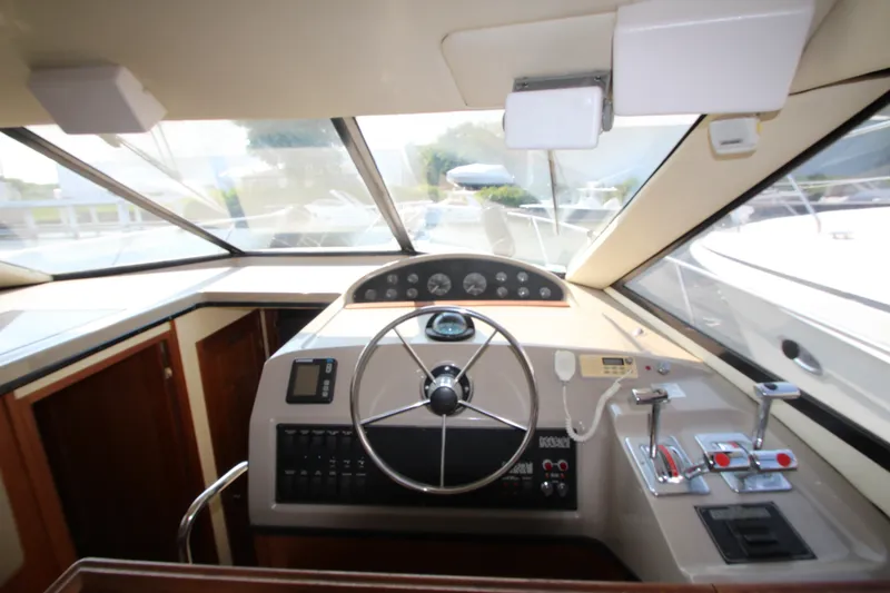 Slide: The Image of 1996 Bayliner 3988 Command Bridge Motoryacht helm with steering wheel and control panel. - 28