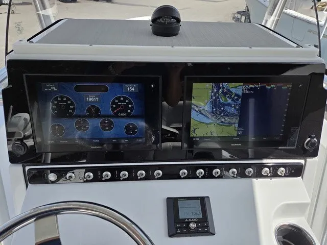 Slide: The Image of The image shows the dashboard of a 2020 Sportsman Masters 247 Bay Boat with two large screens and multiple switches. - 20