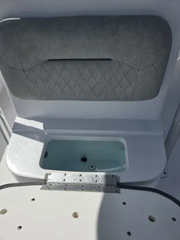 Slide: The Image of A gray cushion above a small, open storage compartment on a boat. - 13