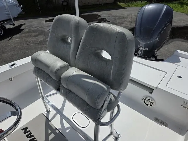 Slide: The Image of Two padded seats on a 2020 Sportsman Masters 247 Bay Boat, with an outboard motor in the background. - 21