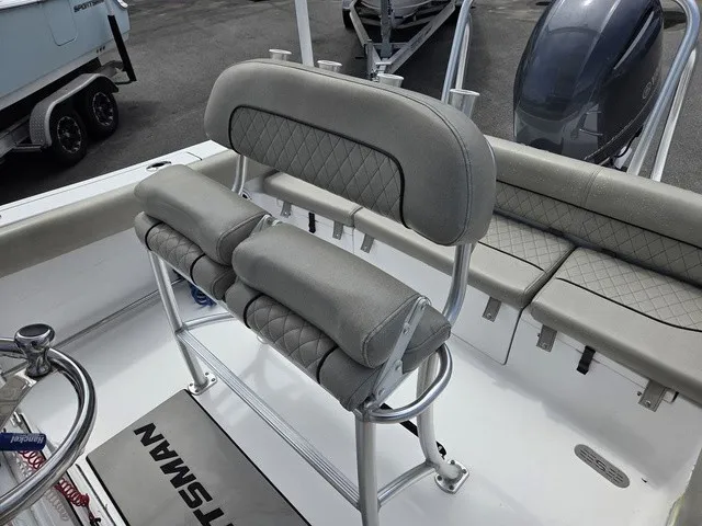 Slide: The Image of The image shows the gray cushioned seats and helm of a Sportsman Heritage 211 Center Console boat. - 19