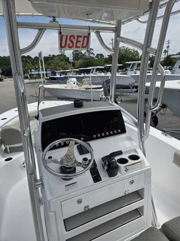 Slide: The Image of The image shows the helm of a 2021 Sportsman Heritage 211 Center Console boat. - 14