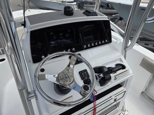 Slide: The Image of The image shows the helm of a 2021 Sportsman Heritage 211 Center Console boat. - 16