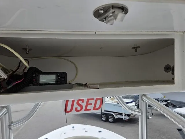 Slide: The Image of An open storage compartment with a radio and cables. A "USED" sign is visible below. - 17