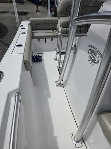 Slide: The Image of The image shows the deck of a 2021 Sportsman Heritage 211 Center Console boat with seating and railings. - 11
