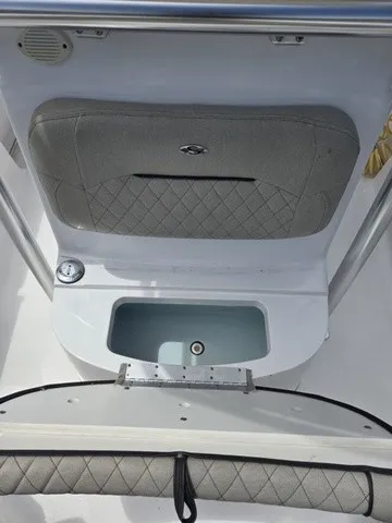 Slide: The Image of The image shows part of the 2021 Sportsman Heritage 211 Center Console boat with a cushioned seat and a small sink. - 10