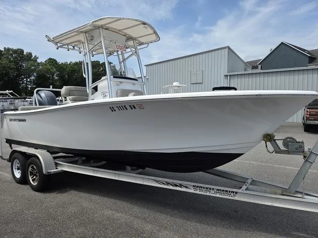 Slide: The Image of A white Sportsman Heritage 211 Center Console boat from 2021 is on a trailer. - 2