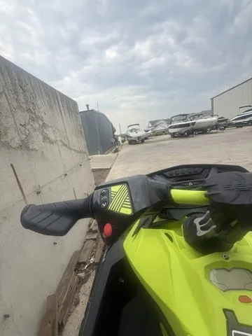 Slide: The Image of A bright yellow Sea-Doo jet ski on a concrete lot beside a wall, with boats in the background. - 6