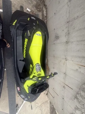 Slide: The Image of A bright yellow Sea-Doo Spark Trixx jet ski sits on a trailer next to a concrete wall. - 4