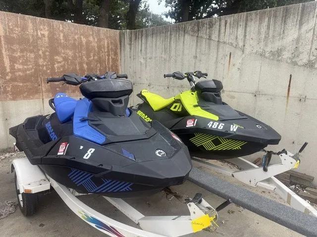 Slide: The Image of Two Sea-Doo Spark Trixx jet skis, one blue and one yellow, are on a trailer. - 2