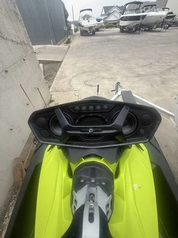 Slide: The Image of A Sea-Doo Spark Trixx 2-up jet ski in bright green sits on a trailer in a yard. - 8