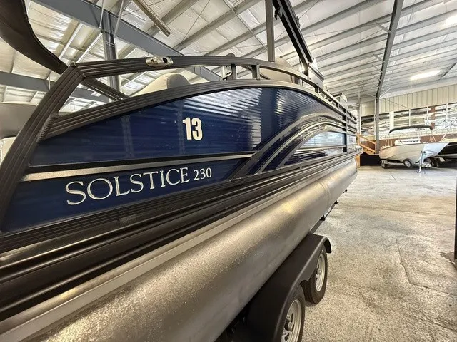 Slide: The Image of A blue 2021 Harris Solstice 250 SLDH is on a trailer in a warehouse. - 10