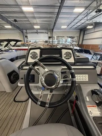 Slide: The Image of The image shows the cockpit of a 2021 Harris Solstice 250 SLDH. It features a modern steering wheel and a Humminbird display. - 24