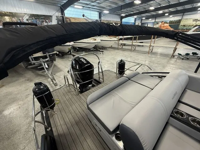 Slide: The Image of The image shows a 2021 Harris Solstice 250 SLDH pontoon boat in a warehouse. - 26