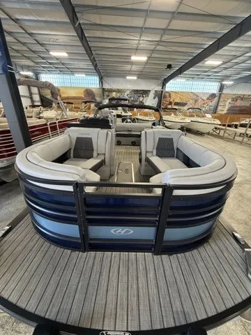 Slide: The Image of A 2021 Harris Solstice 250 SLDH in a showroom. It features gray upholstery and a modern design. - 11