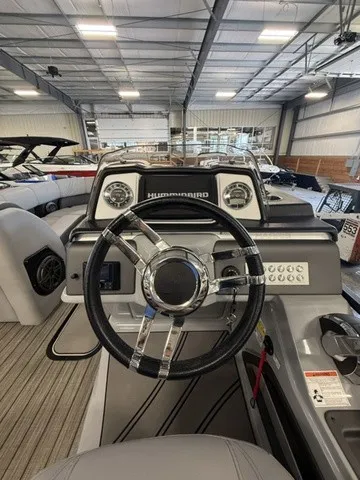 Slide: The Image of The image shows the helm of a 2021 Harris Solstice 250 SLDH inside a warehouse. - 23