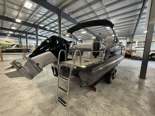 Slide: The Image of A 2021 Harris Solstice 250 SLDH in a warehouse. It features an outboard motor and a ladder. - 8