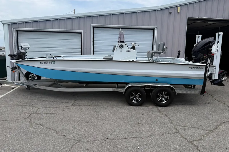 The Image of 2021 Express X23 BAY boat on trailer, parked outside a garage. - 1