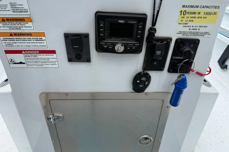 Slide: The Image of Control panel of 2021 Express X23 BAY boat with warnings and capacity details. - 15