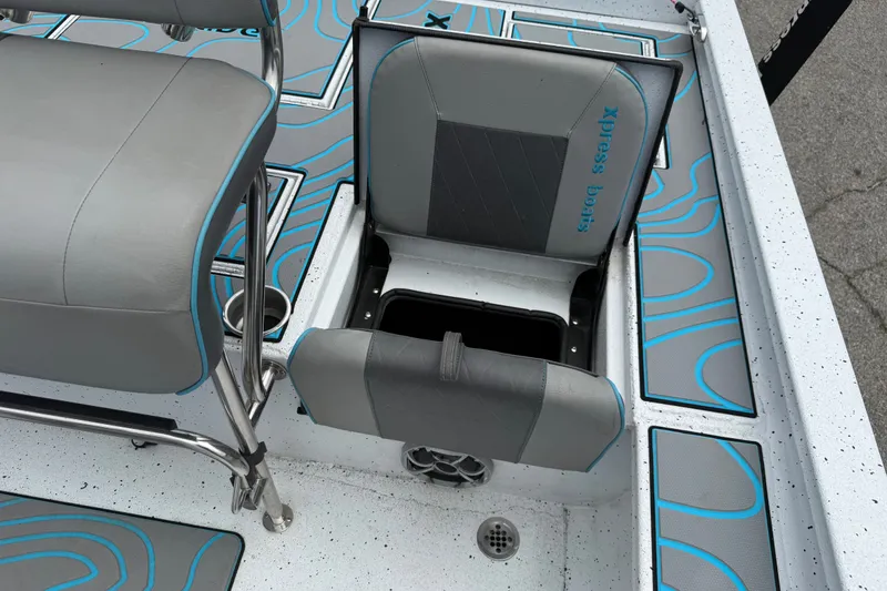 Slide: The Image of 2021 Express X23 BAY boat interior with gray and blue seating and storage compartment. - 18
