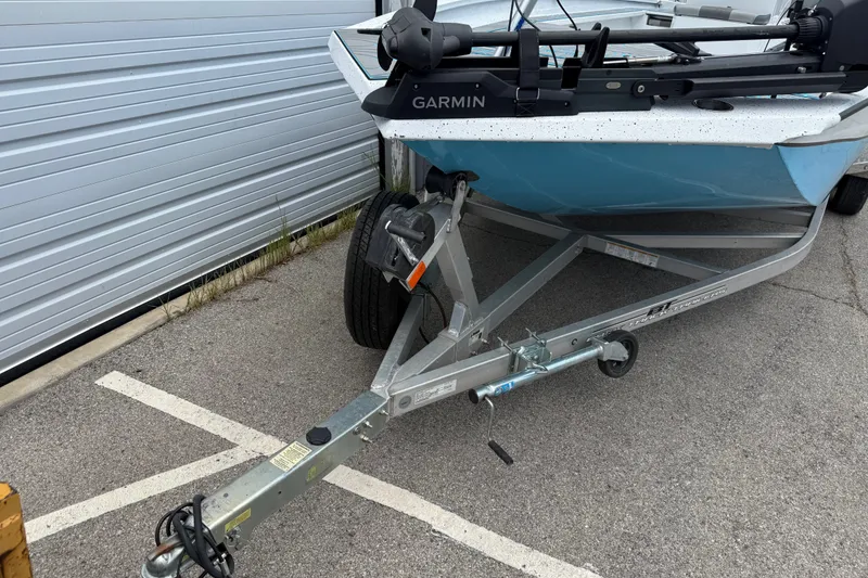 Slide: The Image of 2021 Express X23 BAY boat on trailer with Garmin equipment, parked near a garage. - 6