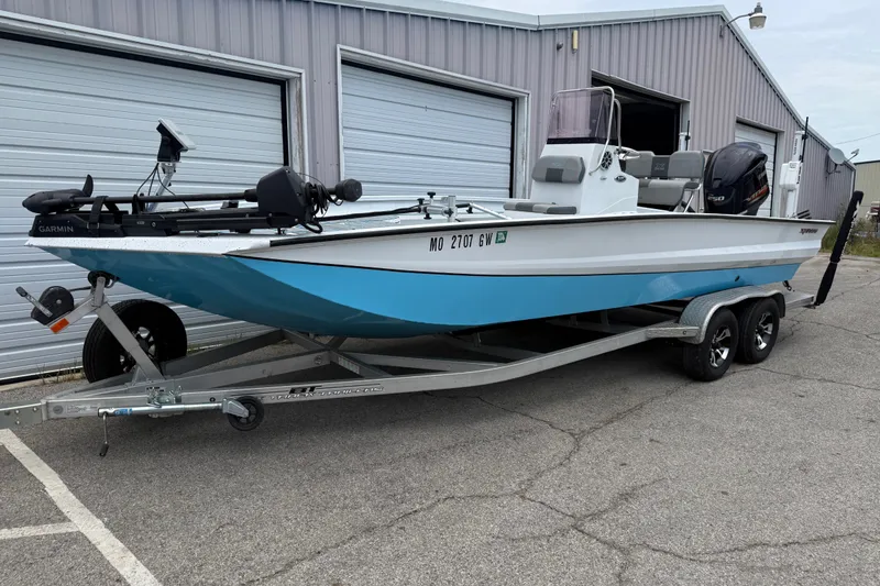 Slide: The Image of 2021 Express X23 BAY boat on trailer, parked outside a garage. - 5
