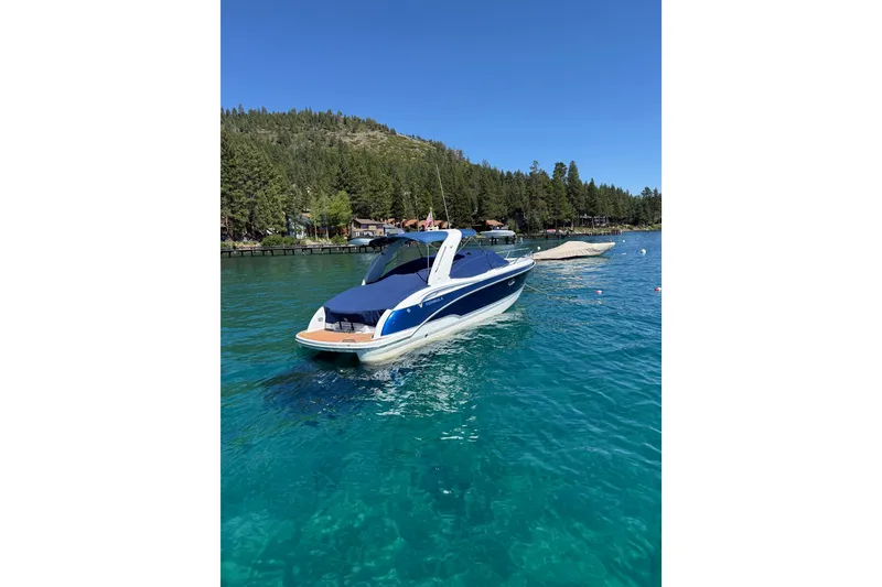 Slide: The Image of 2008 Formula 310 Sun Sport boat on clear blue lake with forested shoreline. - 1
