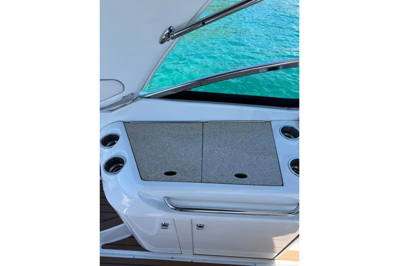 Slide: The Image of 2008 Formula 310 Sun Sport boat interior with countertop and cup holders by the water. - 11