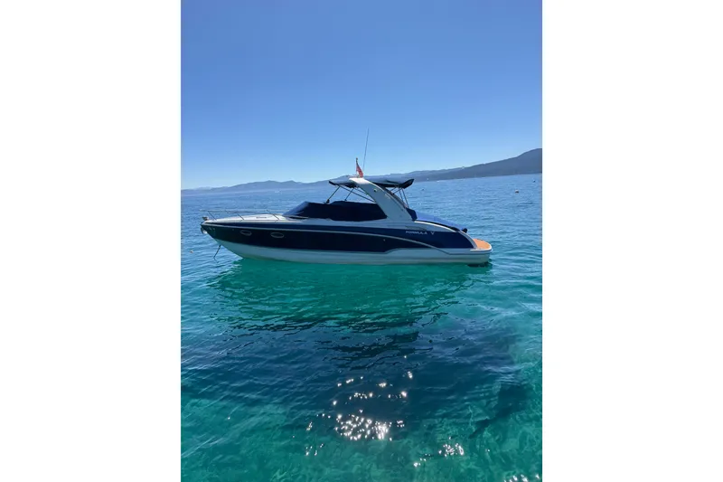 Slide: The Image of 2008 Formula 310 Sun Sport boat on clear blue water under a sunny sky. - 5