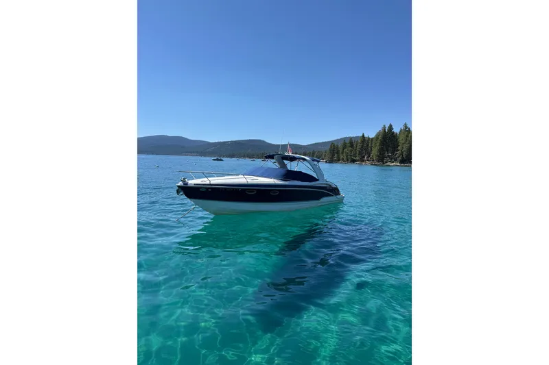 Slide: The Image of 2008 Formula 310 Sun Sport boat on clear blue lake with forested shoreline. - 2