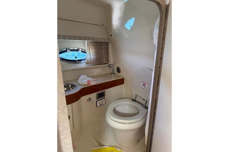 Slide: The Image of 2008 Formula 310 Sun Sport boat bathroom with toilet, sink, and porthole window. - 14
