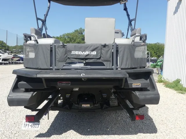 Slide: The Image of The image shows the rear of a 2023 Sea-Doo Switch Sport 21, parked on gravel. - 5