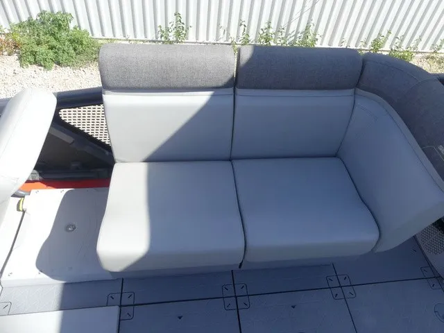 Slide: The Image of The 2023 Sea-Doo Switch Sport 21 features a gray, cushioned bench seat with a modern design. - 11