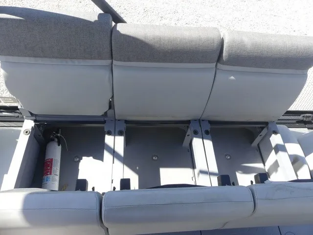 Slide: The Image of The rear seat of a 2023 Sea-Doo Switch Sport 21 with gray cushions and a fire extinguisher underneath. - 18